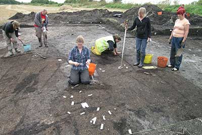 Archaeologists inside a trench